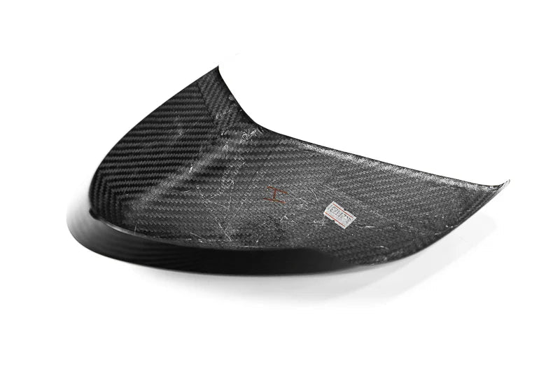 A curved carbon fiber automotive part with a visible woven carbon pattern, photographed on a clean white background. A small Paragon logo sticker is visible on the product, and a larger Paragon watermark is in the bottom right corner.