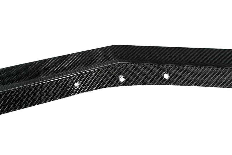 A close-up of a black carbon fiber trim piece with a glossy woven texture and three visible mounting holes, shown against a plain white background with a Paragon logo in the bottom right corner.