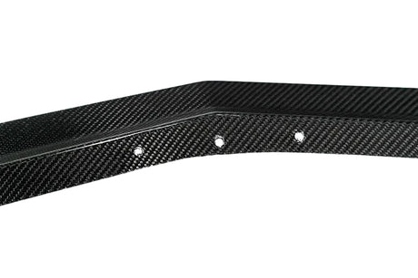 A close-up of a black carbon fiber trim piece with a glossy woven texture and three visible mounting holes, shown against a plain white background with a Paragon logo in the bottom right corner.